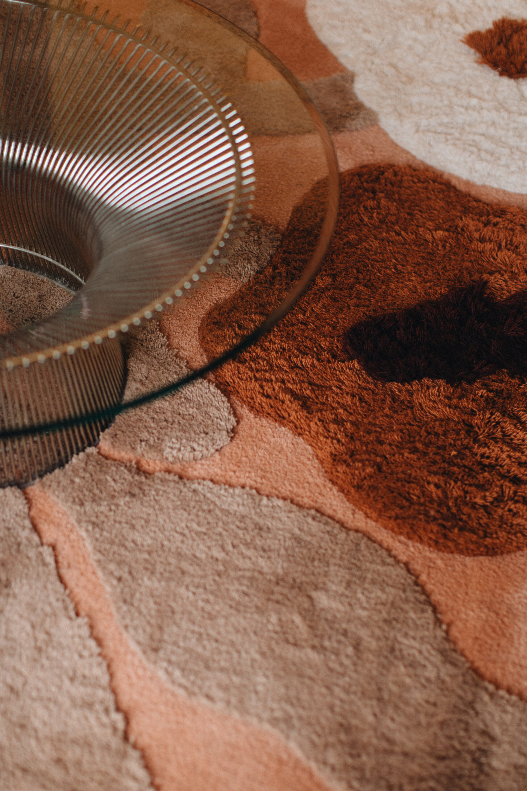 Rug with poppies in terracotta color scheme with table. Terracotta, faded terracotta, cream, dark maroon, sand.