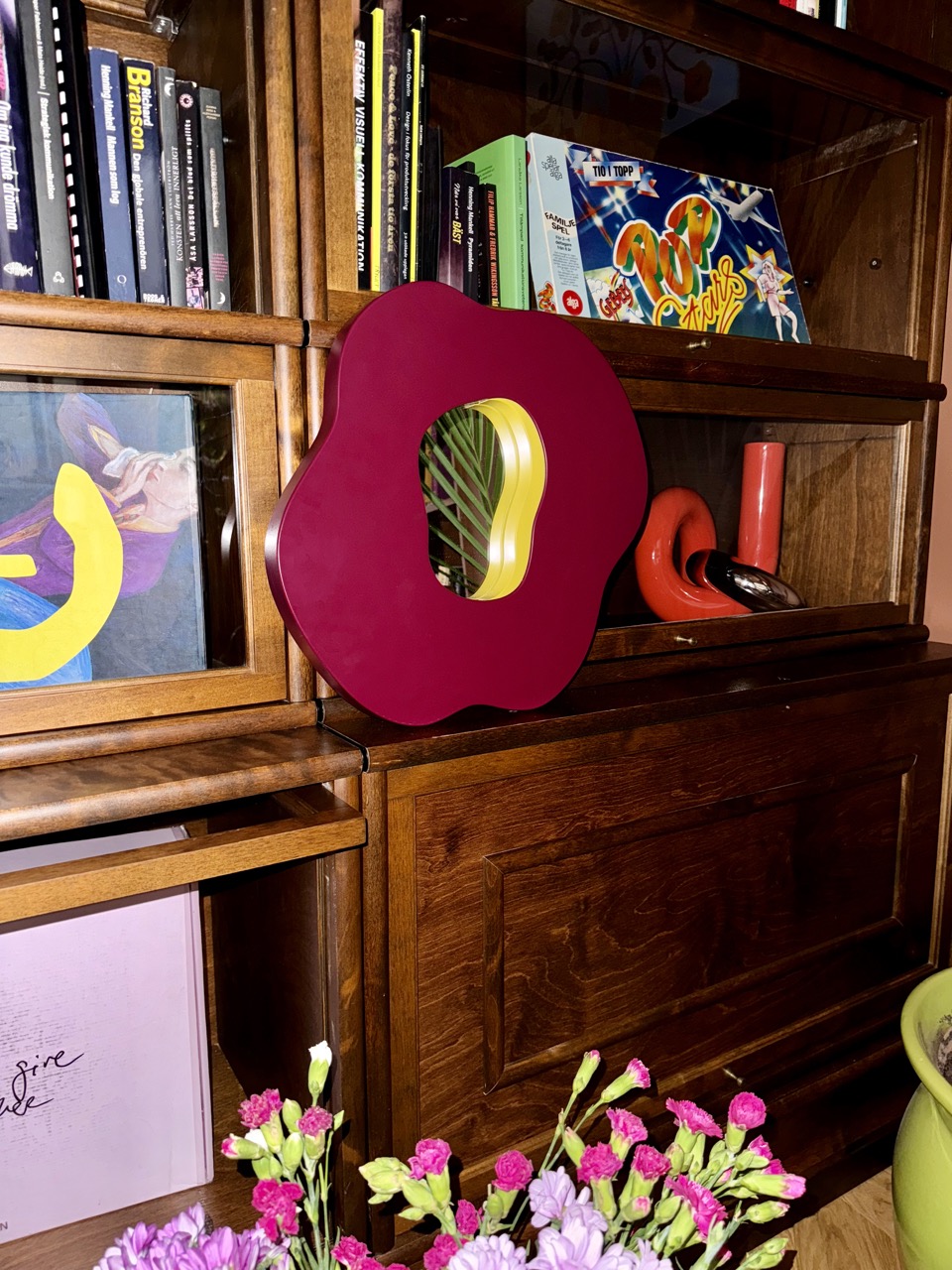 Eggplant and mustard colored poppy mirror in bookshelf