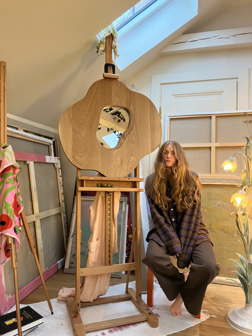 Madelen Möllard with poppy mirror in solid oak standing on an easel in the studio